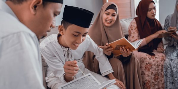 portrait of muslim family reading quran together in livingroom